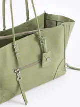 Bolso tote pequeño de cuero vacuno negro, con cierres funcionales en los laterales para mayor apertura y espacio. Incluye bolsillo cruzado interno y tag con aplique metálico.