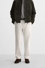Pantalón de vestir color crema, de corte recto, con bolsillos laterales y traseros de ojal con botón.