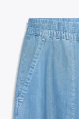Pantalón jogger celeste confeccionado en lino, con tiro alto, cintura elástica ajustable con cordón, bolsillos delanteros y puños elásticos en el bajo.