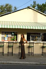 Falda larga tejida color vino tinto con brillo dorado, de corte ajustado y abertura lateral en la pierna.