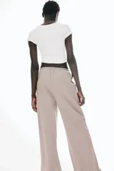 Pantalón largo color topo de punto de algodón, con cintura elástica ajustable con cordón fino. Tiene bolsillos laterales discretos y corte recto.