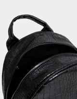 Mochila negra con efecto piel de cocodrilo, bolsillo frontal con cierre, charm de monedero colgante, correas regulables, manija superior, doble cierre superior y bolsillos laterales.