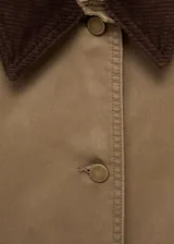 Chaqueta de algodón estilo tejano en color tostado, con diseño recto y manga larga con puños abotonados. Destaca por su cuello camisero de pana en contraste de color marrón oscuro, cierre frontal con botones y dos bolsillos de parche en el frente. Cuenta con forro interior.