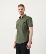 Camisa de hombre de manga corta en lino color blanco, con cuello clásico, botonadura frontal y bolsillo de parche en el pecho. Corte recto.