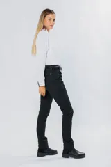 Pantalón de gabardina gris oscuro, corte skinny, con bolsillos delanteros y traseros. Se ajusta a la cintura con cinturón de cuero marrón con hebilla dorada.