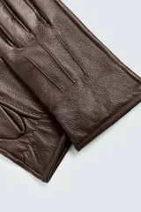 Guantes de cuero negro con forro interior de punto y costuras decorativas en el dorso.