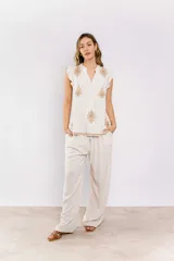 Pantalón de lino color beige, de corte amplio y cintura con cordón ajustable.