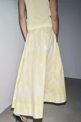 Falda midi de tiro alto confeccionada en hilatura de algodón con estampado geométrico en tonos rosa, marrón y bordó. Detalle de pliegues en cintura y bajo evasé. Cierre con cremallera oculta en costura.