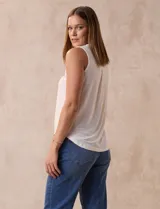 Blusa sin mangas color blanco, marca Absolutely Famous, confeccionada en seda fría. Presenta escote en V con detalle de lazo entrelazado.