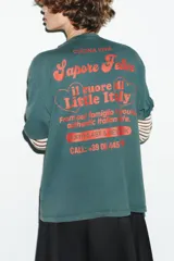 Camiseta de manga corta color verde azulado (teal) con efecto lavado, corte oversize y cuello redondo. Estampado frontal en color rojo con el texto "Sapore Felice" en tipografía cursiva.