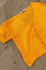 Blusa tejida artesanalmente en hilado 70% algodón y 30% acrílico, color naranja, con cuello en V y cierre con lazos.