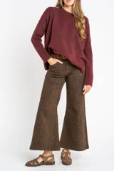 Sweater color marrón claro de tejido de punto, con cuello redondo y mangas largas.