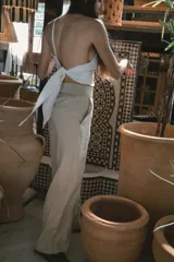 Pantalón de vestir negro de tiro alto, corte recto y pierna ancha. Presenta pliegues frontales y bolsillos laterales.