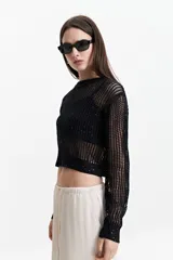 Sweater negro de tejido calado con escote redondo y mangas largas.