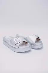 Sandalias plateadas veganas con plataforma y hebilla decorativa.