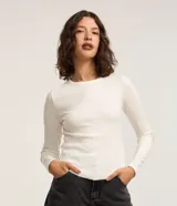 Blusa de rib color blanco, con cuello redondo, mangas largas y bajo redondeado.