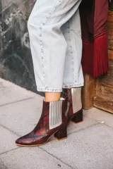 Botín de cuero con estampado de piel de serpiente en tonos marrón y rojo, con elásticos laterales plateados y tacón cuadrado.