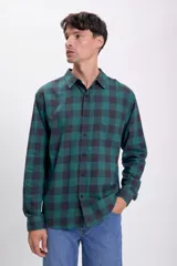 Camisa de manga larga con estampado de cuadros grandes en verde petróleo y negro, con cuello clásico y bolsillo en el pecho.