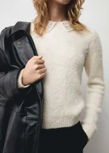 Sweater color crema de tejido de punto con cuello polo y detalle de strass.