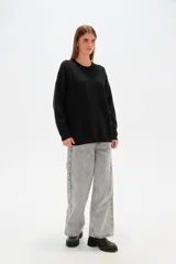 Sweater color crema, de corte holgado, con cuello redondo y mostacillas decorativas.