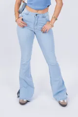 Pantalón de jean celeste de corte acampanado con aberturas en el ruedo.