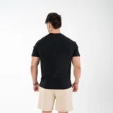 Remera negra de algodón y elastano, corte slim fit, con cuello redondo y logo 'GAINS' estampado en el pecho.