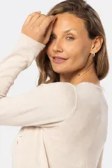 Buzo color beige de tejido de punto con bordado de pequeñas flores blancas.