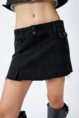 Minifalda de jean tiro bajo color negro con silueta evasé, dos tajos delanteros y ruedo desflecado.