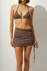 Minifalda de playa con estampado a rayas verticales azules y negras, con cordones laterales ajustables.