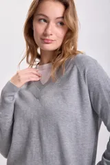 Sweater gris de tejido de punto con escote en V.
