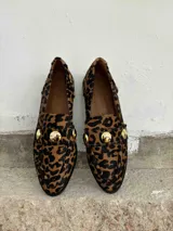 Mocasines de cuero con estampado animal print de cebra en blanco y negro, con apliques de strass plateados.