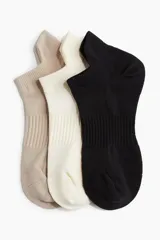 Pack de tres pares de medias deportivas cortas, confeccionadas en tejido funcional DryMove™ que absorbe la humedad. Incluye un par color beige, un par color crema y un par color negro.