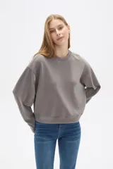 Buzo color beige de corte ancho y cuello redondo.