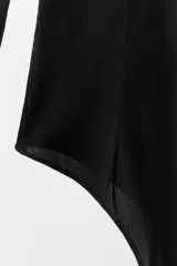 Body negro de tejido tipo media con cuello redondo y manga larga.