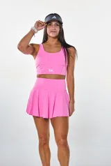 Conjunto deportivo fucsia compuesto por un top con logo "bk." y una minifalda tableada.