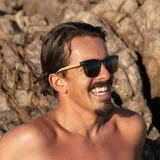 Lentes de sol con montura de madera color marrón y lentes verdes.