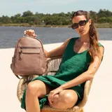 Mochila negra de símil cuero con bolsillo frontal con cierre. En su interior tiene dos bolsillos con cierre y uno abierto con división. Tiene asa de mano y correas regulables.