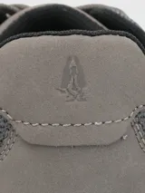 Zapatillas grises de tejido de punto con cordones, suela blanca y puntera marrón.