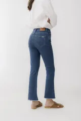 Pantalón jean cropped azul con corte acampanado y ruedo desflecado.