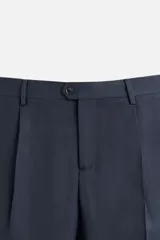 Pantalón de vestir azul marino, de corte recto, con pinzas frontales, bolsillos laterales y traseros de ojal. Se cierra con cremallera y doble botón.