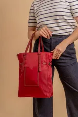 Cartera tipo tote bag color negro, con doble asa de mano y correa bandolera ajustable. Presenta un bolsillo rectangular en el frente.