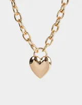 Collar corto dorado con cadena de eslabones gruesos y dije de corazón inflado.