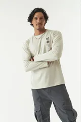 Remera de manga larga gris con cuello redondo y estampado con logo y texto en el frente.