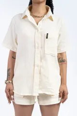 Camisa negra de manga corta con cuello clásico, bolsillo en el pecho y corte holgado.