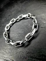 Pulsera plateada de acero inoxidable con eslabones medianos pulidos y cierre de mosquetón.