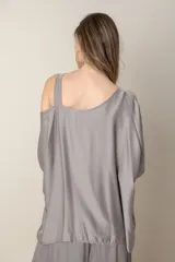 Blusa italiana gris de viscosa, lisa, con corte irregular y un hombro descubierto. De calce holgado.