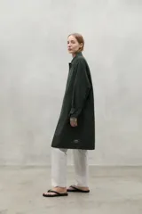 Chaqueta oversized en color verde, confeccionada con 50% poliéster reciclado y 50% algodón, con cierre frontal y bolsillos.