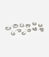 Set de seis pares de aros plateados con diferentes diseños de argollas. Incluye argollas lisas, argollas cuadradas y argollas con textura. Cierre con poste.