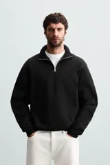 Sudadera color crema de corte recto, con cuello polo y cierre de cremallera metálica.