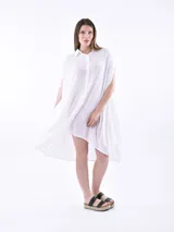 Vestido blanco, de corte amplio y sin mangas, con botones frontales y diseño suelto.